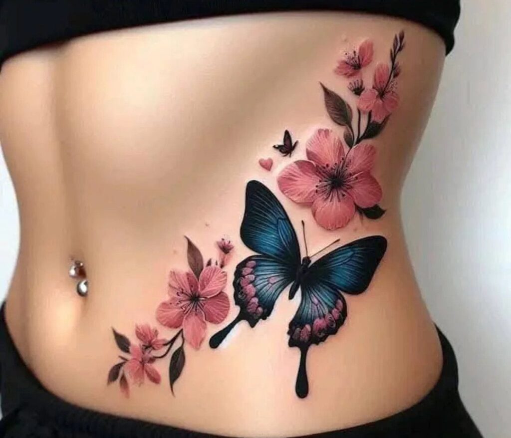 A blue butterfly and pink floral tattoo decorating a woman's stomach and side.